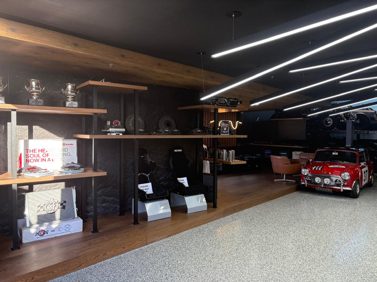 Speed Factor showroom with lit parts displays and cars in the background