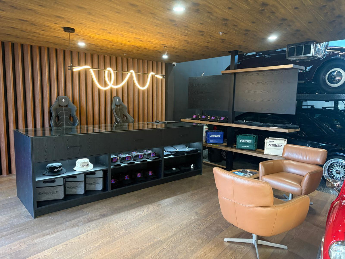 Speed Factor showroom lounge with wood-slat wall, display shelving and leather chairs