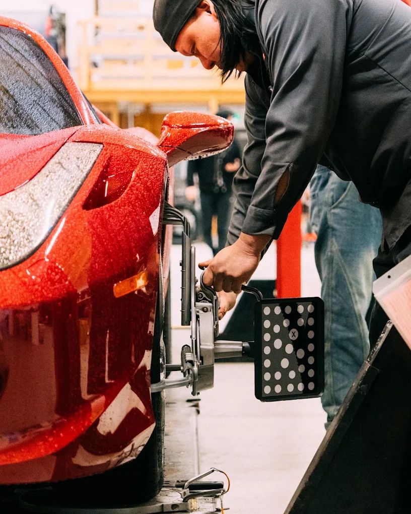 Alignment clamp mounted on a red car wheel